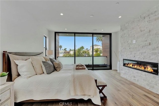 518 8th St, Huntington Beach, CA 92648 - bedroom featuring access to exterior, a stone fireplace, light wood-style flooring, a wall of windows, and recessed lighting