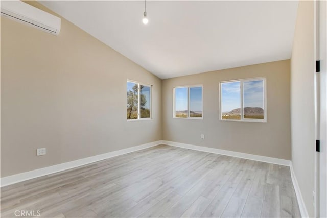 1809 Delgada Ave, Landers, CA 92285 - unfurnished room with an AC wall unit, lofted ceiling, light wood finished floors, and baseboards