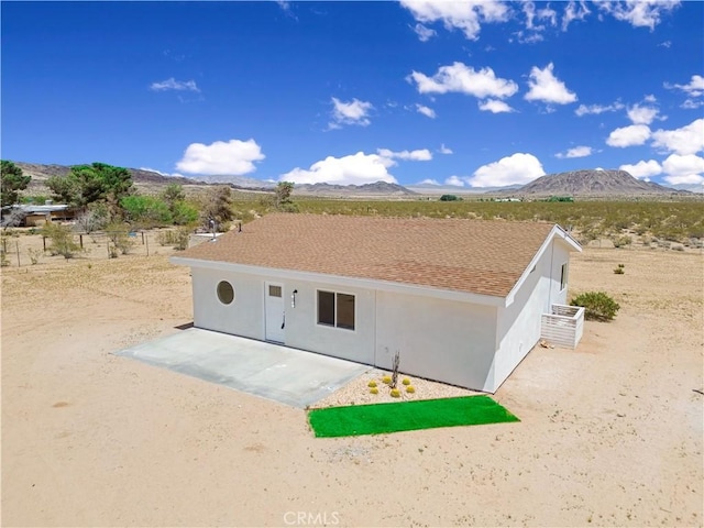 1809 Delgada Ave, Landers, CA 92285 - back of property with a mountain view, stucco siding, and a patio area