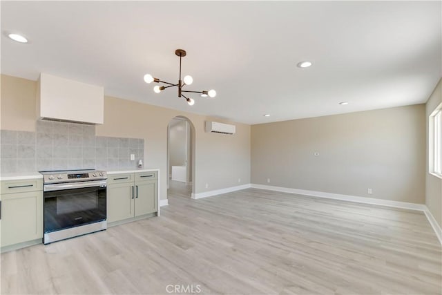 1809 Delgada Ave, Landers, CA 92285 - kitchen with electric range, arched walkways, a chandelier, a wall mounted AC, and baseboards