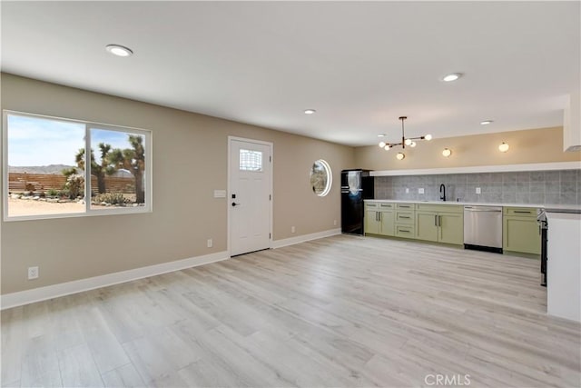 1809 Delgada Ave, Landers, CA 92285 - kitchen featuring stainless steel dishwasher, green cabinets, freestanding refrigerator, a chandelier, and decorative backsplash