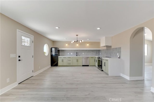 1809 Delgada Ave, Landers, CA 92285 - kitchen with appliances with stainless steel finishes, light countertops, arched walkways, decorative backsplash, and green cabinetry