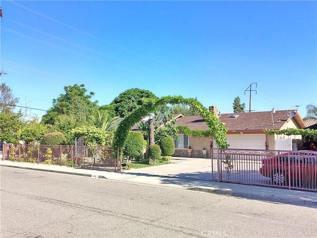 view of front of home featuring driveway, fence, a garage, and stucco siding