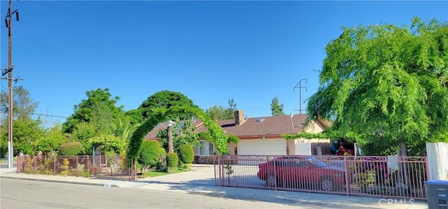 obstructed view of property with an attached garage, fence, and driveway