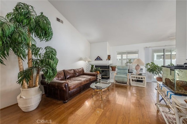 5470 Watson St, Banning, CA 92220 - living room with vaulted ceiling, a fireplace, and wood-type flooring