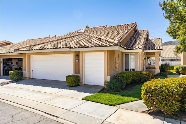 5470 Watson St, Banning, CA 92220 - view of property featuring a garage, stucco siding, driveway, and a tiled roof