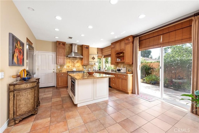 11803 Sortino Ct, Moorpark, CA 93021 - kitchen with wall chimney exhaust hood, tasteful backsplash, light stone countertops, recessed lighting, and a center island