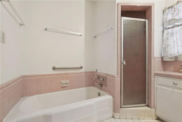 1845 W 91st Pl, Los Angeles, CA 90047 - bathroom with tile walls, a shower stall, a bath, tile patterned floors, and wainscoting