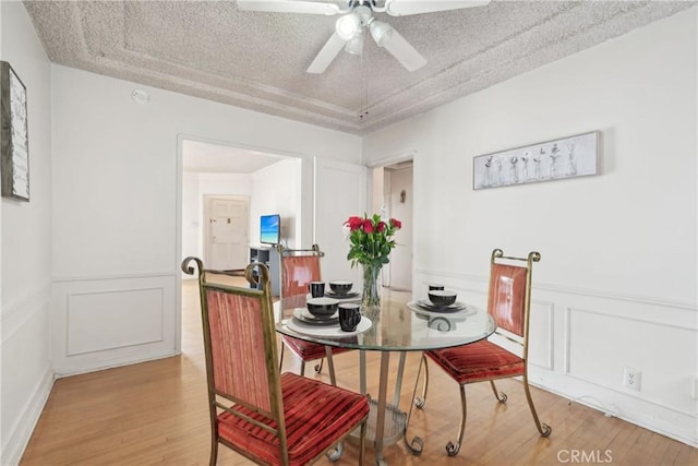 1845 W 91st Pl, Los Angeles, CA 90047 - dining space featuring light wood finished floors, ceiling fan, wainscoting, and a decorative wall