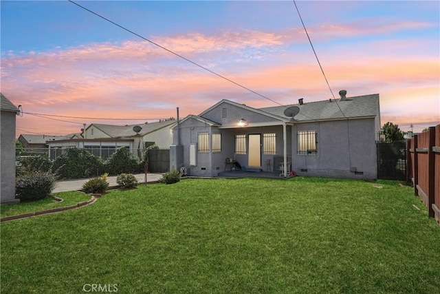 1845 W 91st Pl, Los Angeles, CA 90047 - back of property at dusk with stucco siding and crawl space
