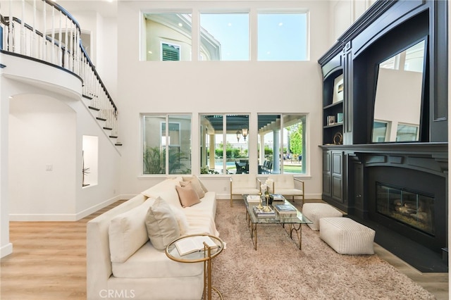 20112 Via Cellini, Porter Ranch, CA 91311 - living room with wood finished floors, a high ceiling, baseboards, and a glass covered fireplace