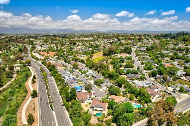 aerial view of property's location with a highway, nearby suburban area, a mountainous background, and a pool area