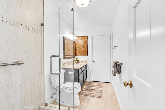 bathroom featuring a stall shower, vanity, and toilet