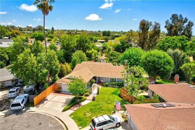 view of subject property with a tree filled landscape