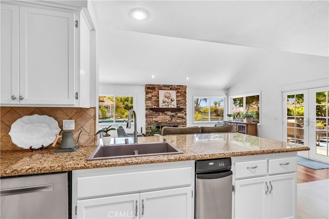 kitchen with a sink, dishwasher, light stone counters, white cabinetry, and recessed lighting