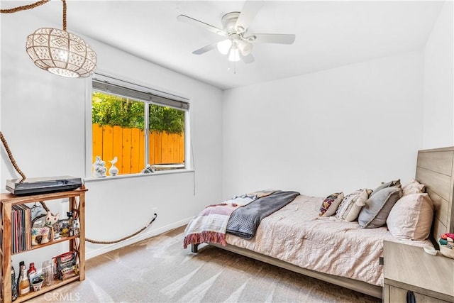 carpeted bedroom with baseboards and a ceiling fan