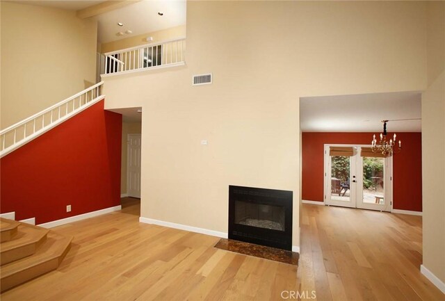 8016 Cora St, Sunland, CA 91040 - unfurnished living room with stairway, wood finished floors, a high ceiling, a chandelier, and baseboards