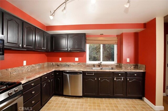 8016 Cora St, Sunland, CA 91040 - kitchen featuring stainless steel appliances, a sink, rail lighting, light stone counters, and baseboards