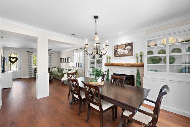 2 Anglesite, Rancho Santa Margarita, CA 92688 - dining room with crown molding, a chandelier, a fireplace, dark wood-style flooring, and baseboards