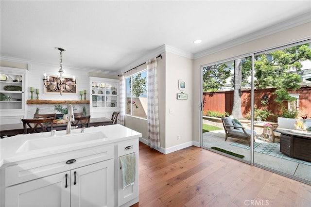2 Anglesite, Rancho Santa Margarita, CA 92688 - kitchen with a chandelier, baseboards, light wood finished floors, white cabinets, and a sink