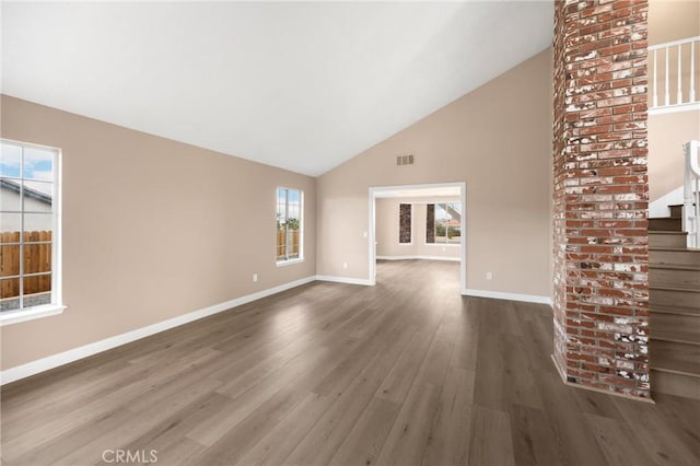 17725 Tude Ln, Apple Valley, CA 92307 - unfurnished living room with wood finished floors, baseboards, stairs, and high vaulted ceiling