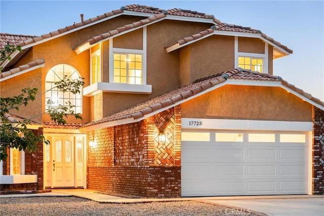 17725 Tude Ln, Apple Valley, CA 92307 - mediterranean / spanish-style home with concrete driveway, stucco siding, a tiled roof, and an attached garage