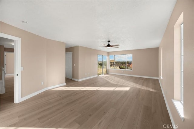 17725 Tude Ln, Apple Valley, CA 92307 - unfurnished living room with ceiling fan, baseboards, and light wood-type flooring