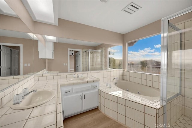 17725 Tude Ln, Apple Valley, CA 92307 - full bath featuring double vanity, a shower stall, a whirlpool tub, and wood finished floors