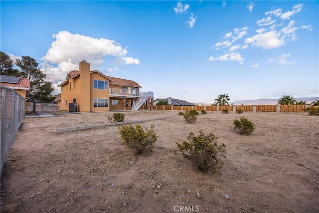 17725 Tude Ln, Apple Valley, CA 92307 - rear view of property featuring stairs, central air condition unit, stucco siding, and a chimney