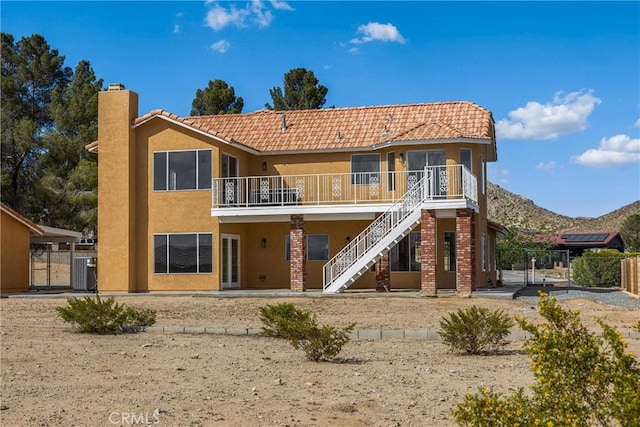 17725 Tude Ln, Apple Valley, CA 92307 - back of property featuring stucco siding, a gate, a chimney, stairway, and a tiled roof