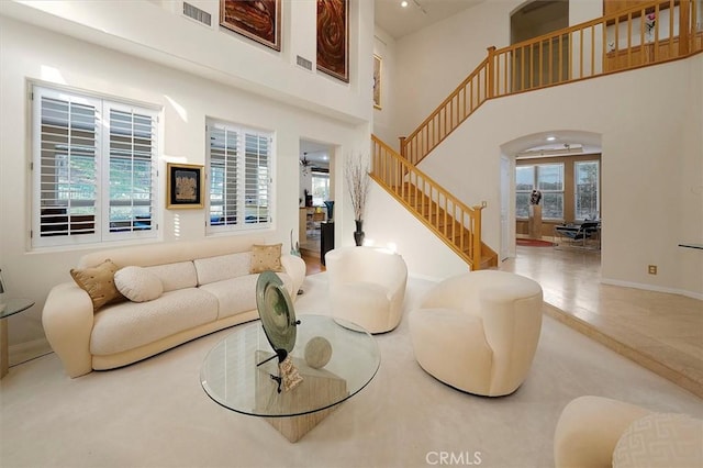 25415 Verne Ct, Stevenson Ranch, CA 91381 - living area with arched walkways, stairs, a high ceiling, and baseboards