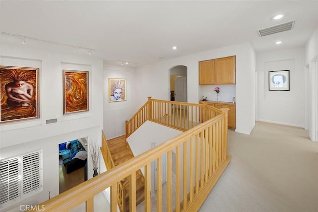 25415 Verne Ct, Stevenson Ranch, CA 91381 - hall with an upstairs landing, arched walkways, recessed lighting, light colored carpet, and rail lighting