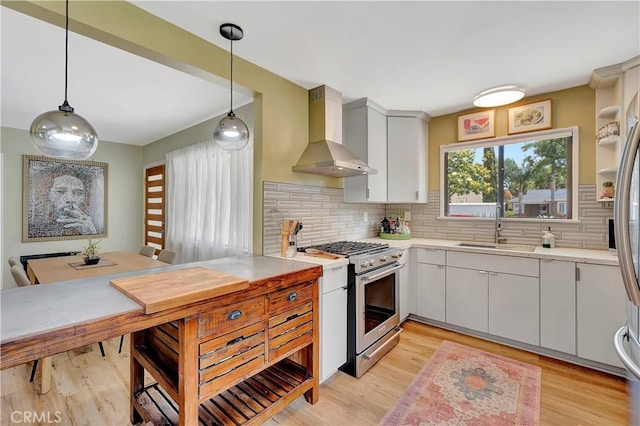 3235 Faust Ave, Long Beach, CA 90808 - kitchen featuring stainless steel range, wall chimney range hood, a sink, light countertops, and decorative backsplash