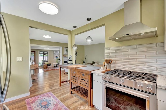 3235 Faust Ave, Long Beach, CA 90808 - kitchen with appliances with stainless steel finishes, wall chimney range hood, decorative backsplash, light wood-style floors, and pendant lighting