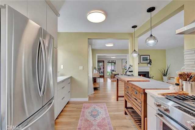 3235 Faust Ave, Long Beach, CA 90808 - kitchen featuring stainless steel appliances, white cabinetry, light countertops, decorative light fixtures, and light wood-style flooring