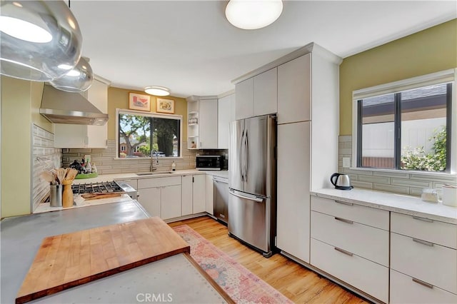 3235 Faust Ave, Long Beach, CA 90808 - kitchen with stainless steel appliances, a sink, wall chimney exhaust hood, and tasteful backsplash
