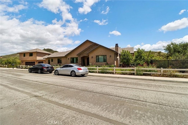 4004 Snowgoose St, Simi Valley, CA 93065 - view of front of house featuring fence, a chimney, and stucco siding