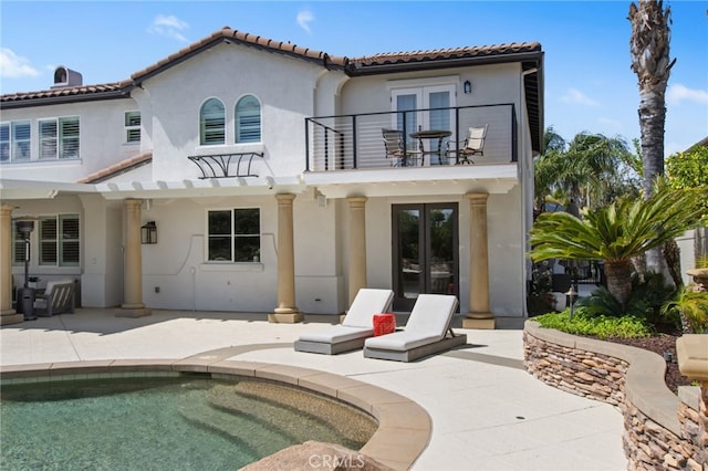 32429 Castle Ct, Temecula, CA 92592 - back of property with french doors, a balcony, stucco siding, a patio, and an outdoor pool