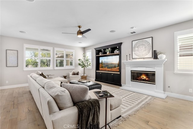 32429 Castle Ct, Temecula, CA 92592 - living room with ceiling fan, hardwood / wood-style flooring, a glass covered fireplace, and plenty of natural light