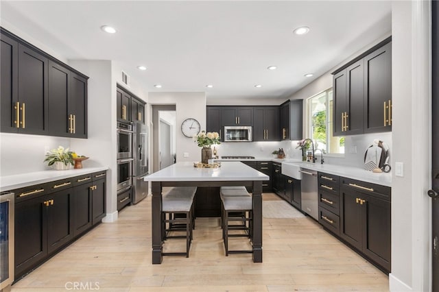 32429 Castle Ct, Temecula, CA 92592 - kitchen featuring stainless steel appliances, a kitchen bar, light wood-style floors, recessed lighting, and light countertops