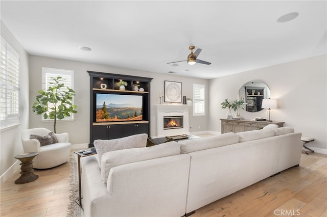 32429 Castle Ct, Temecula, CA 92592 - living area with ceiling fan, light wood-style floors, and a glass covered fireplace