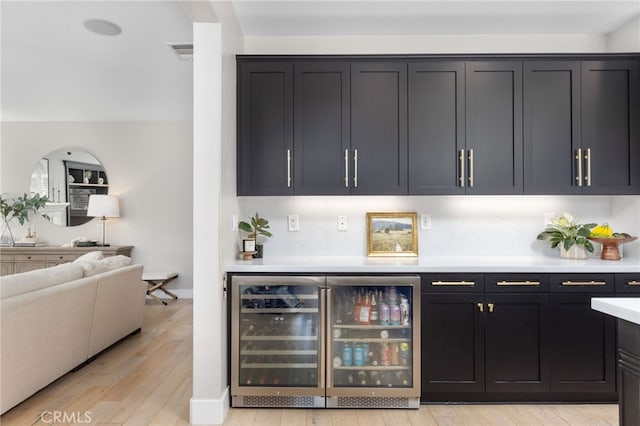 32429 Castle Ct, Temecula, CA 92592 - indoor dry bar featuring light wood-type flooring, wine cooler, and baseboards