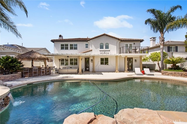 32429 Castle Ct, Temecula, CA 92592 - rear view of house with a balcony, stucco siding, a patio area, a chimney, and a tiled roof