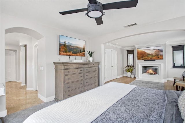 32429 Castle Ct, Temecula, CA 92592 - bedroom with arched walkways, a glass covered fireplace, and a ceiling fan