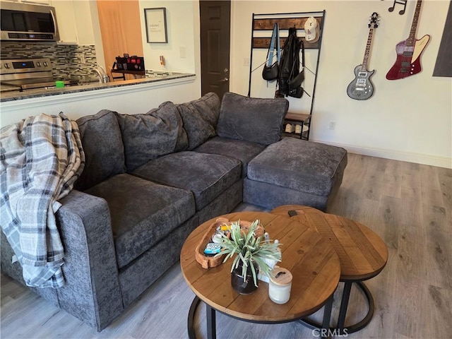 living area featuring light wood-style floors and baseboards
