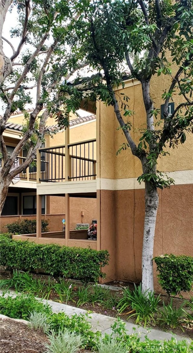 view of side of home featuring a balcony and stucco siding