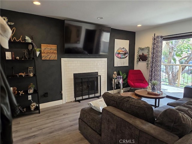 living area with recessed lighting, wood finished floors, baseboards, and a fireplace