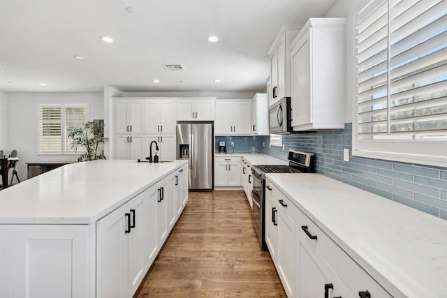 4203 Calle Del Vis, Oceanside, CA 92057 - kitchen featuring appliances with stainless steel finishes, a sink, light wood-style flooring, recessed lighting, and white cabinets