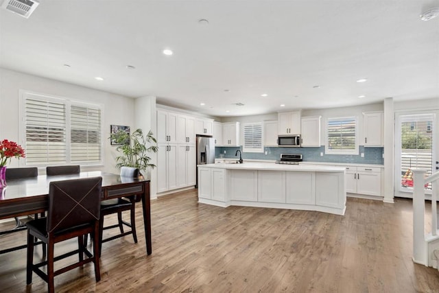 4203 Calle Del Vis, Oceanside, CA 92057 - kitchen featuring a sink, appliances with stainless steel finishes, white cabinets, light countertops, and tasteful backsplash
