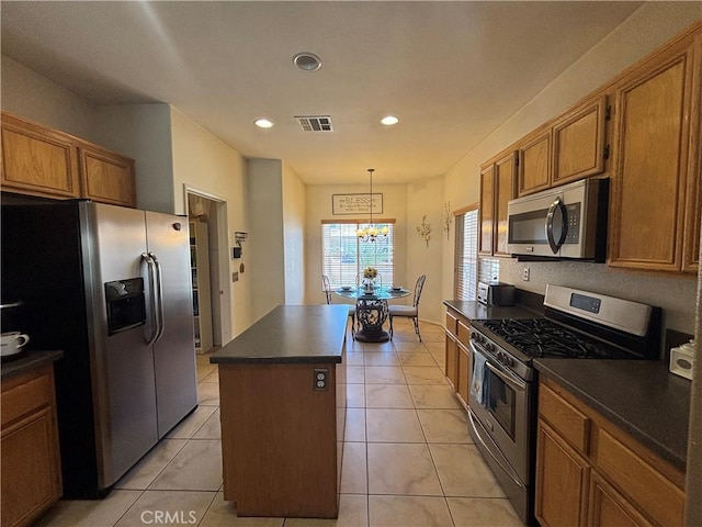 1800 Windermere Dr, Lancaster, CA 93534 - kitchen with appliances with stainless steel finishes, dark countertops, a center island, a chandelier, and brown cabinetry
